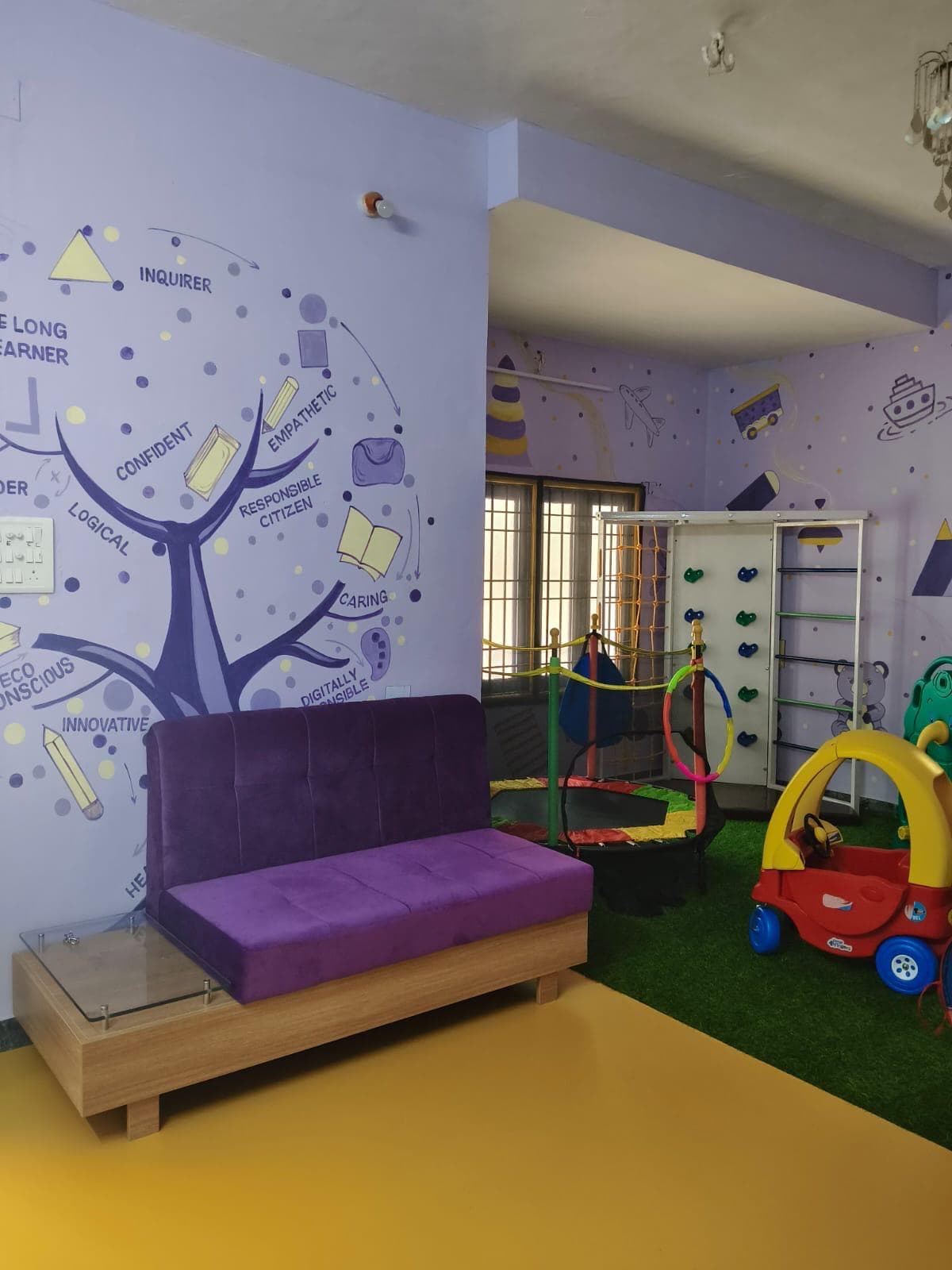 Activity room with learner-profile mural, climbing wall and trampoline